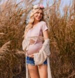 Pregnant woman wearing blush short sleeve maternity top outdoors