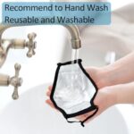 Hands rinsing a cloth mask under a faucet with a hand-wash note