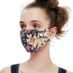 Navy and orange flower print cotton mask worn by a woman, side view